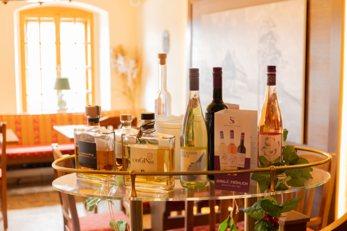 Wein- und Wodkaflaschen stehen auf einer Glasablage