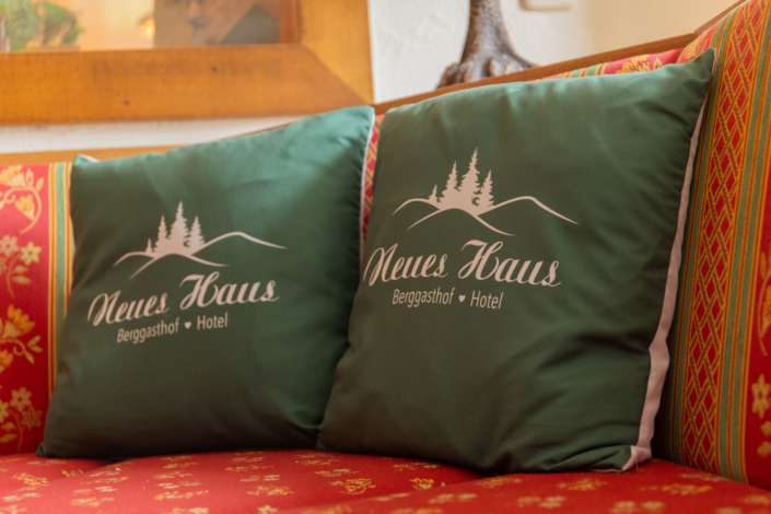 2 Grüne Kissen auf einer roten Bank