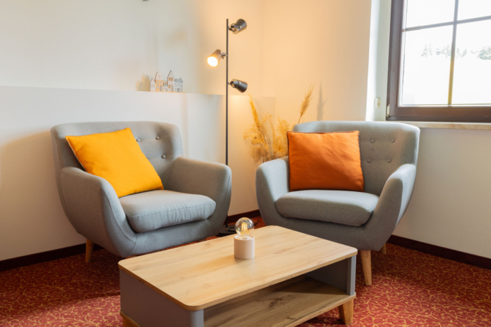 Zwei graue Sessel stehen an einem braunen Couchtisch