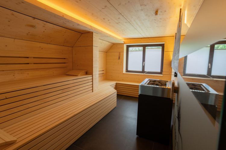 Eine Sauna mit Saunabank, Fenster und Saunaofen