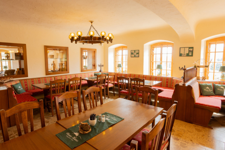 Eine Gaststube mit Tischen und Stühlen und einem Kronleuchter